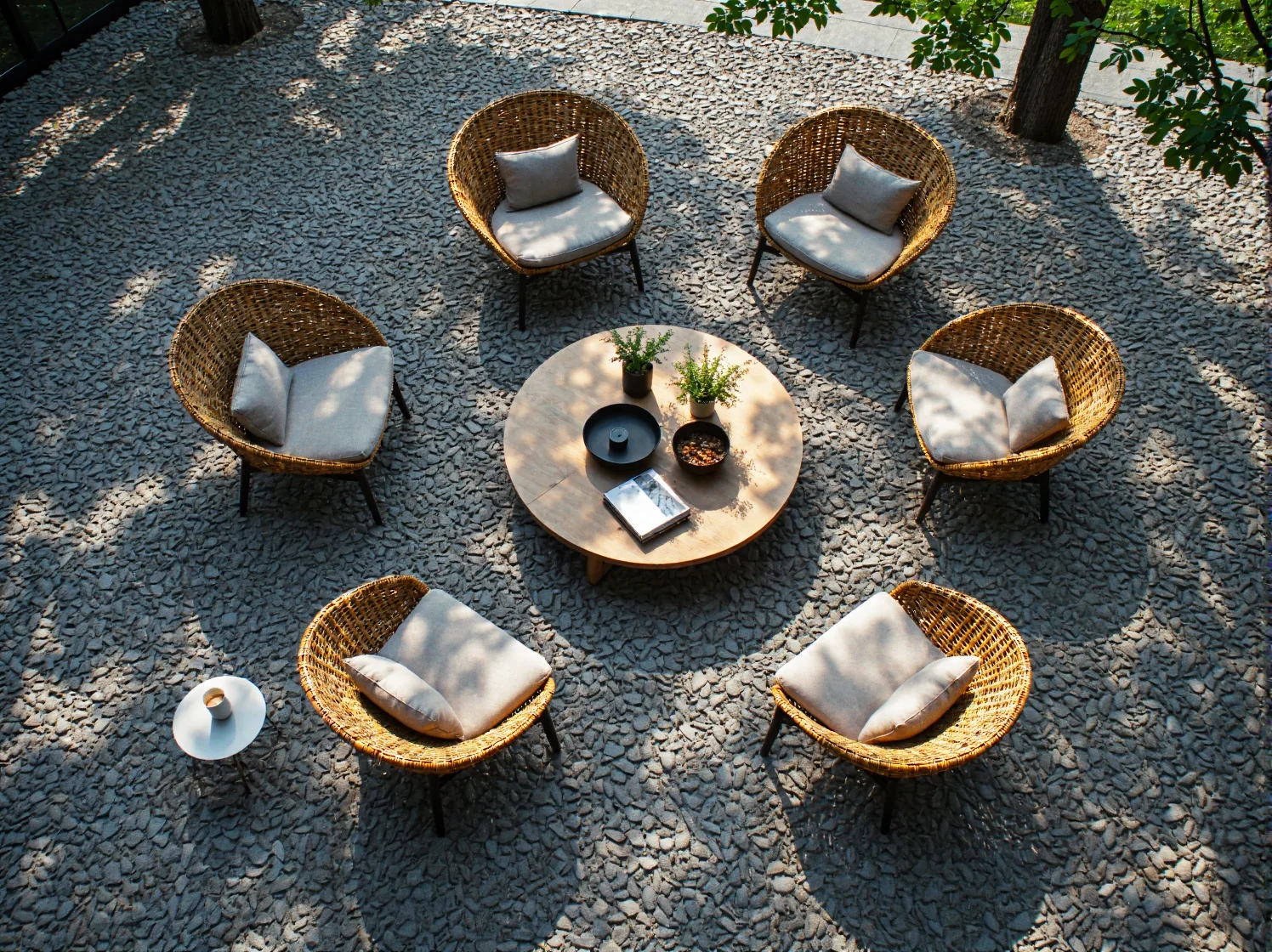 Stylowa strefa relaksu w ogrodzie coworkingowym z wygodnymi, ekologicznymi fotelami i bujną roślinnością.